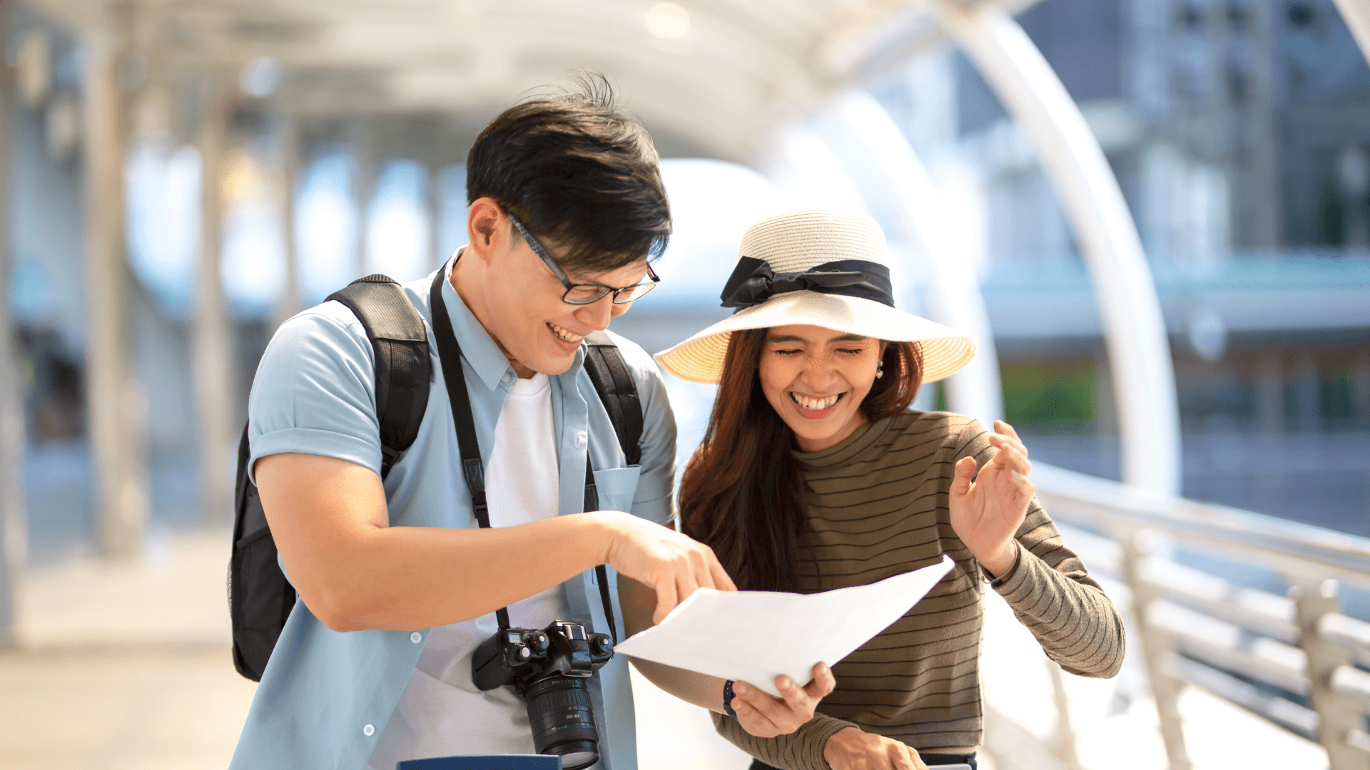 Couple laughing together while looking at a map for directions