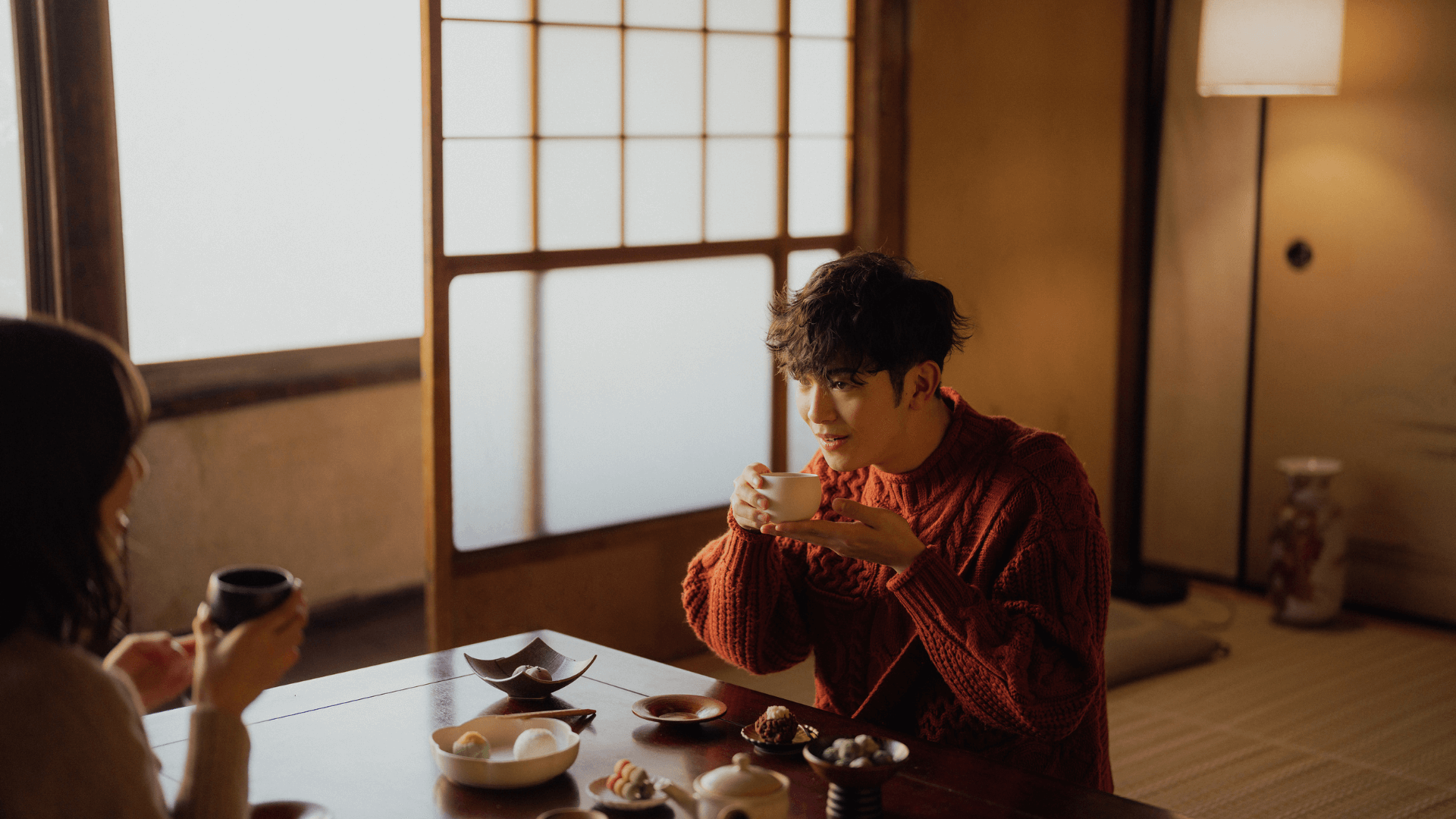 A Man and a woman begin to eat at Ja apanese restaurant, observing tatami style dining